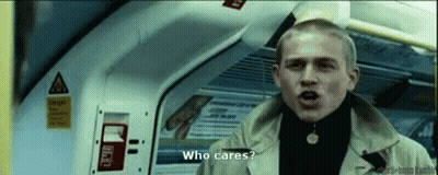 Man In Trench Coat Talking On Train Asking Who Cares GIF