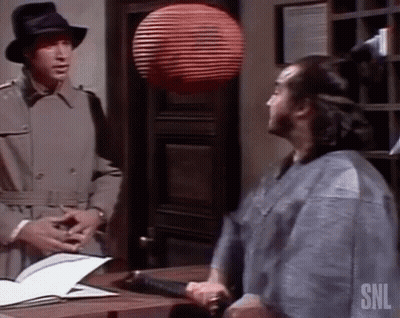 Man In Trench Coat Talking To Man In Kimono GIF