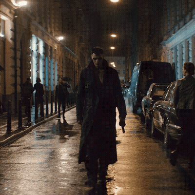Man In Trench Coat Walking Down Dark Street GIF