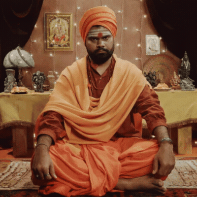 Man In Turban And Orange Robe At Table GIF