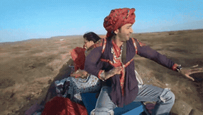 Man In Turban And Purple Shirt Sitting On Blue Box GIF
