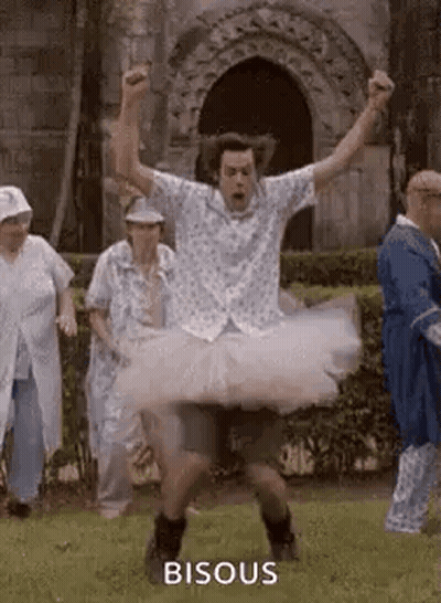 Man In Tutu Jumping While Group Watches GIF