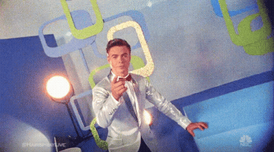 Man In Tuxedo And Bow Tie In Front Of NBC Sign GIF