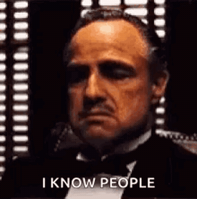 Man In Tuxedo And Bow Tie Sitting In Front Of Window GIF