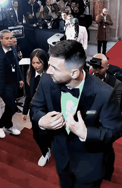 Man In Tuxedo And Bow Tie Walking Down Red Carpet GIF