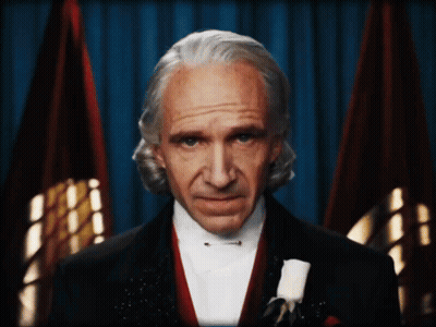 Man In Tuxedo And Bow Tie With Two Flags GIF