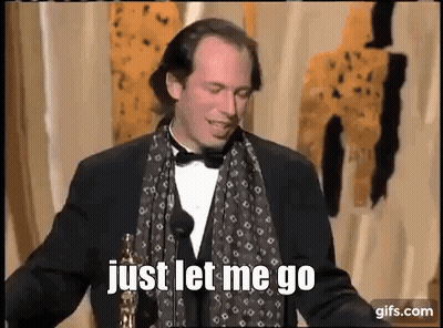 Man In Tuxedo And Scarf Holding Oscar At Microphone GIF
