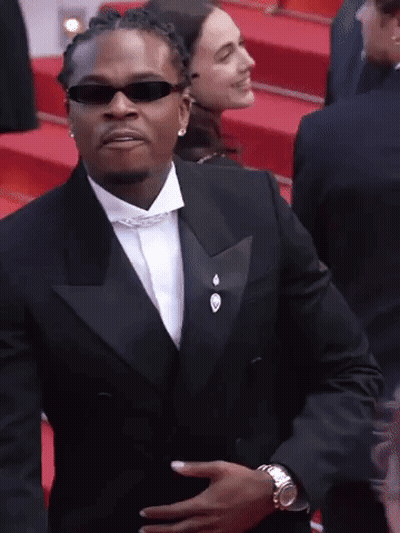 Man In Tuxedo And Sunglasses Holding Stomach GIF