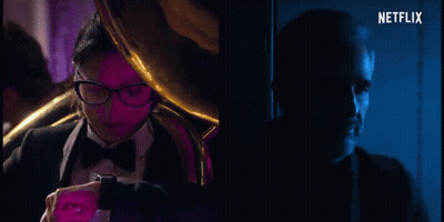Man In Tuxedo And Woman In Black Turtleneck Netflix Ad GIF