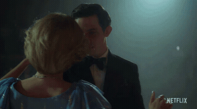 Man In Tuxedo And Woman In Blue Dress Dancing With Netflix Logo GIF