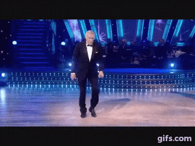 Man In Tuxedo Dancing In Front Of Orchestra GIF