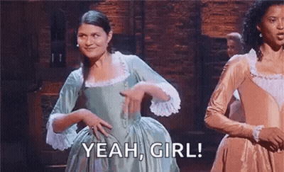 Man In Tuxedo Dancing On Stage In Front Of Man Lying On Table GIF