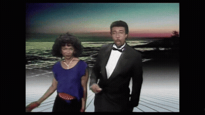 Man In Tuxedo Dancing With Woman In Blue Top GIF