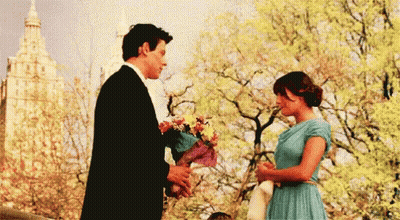 Man In Tuxedo Giving Woman Flowers GIF