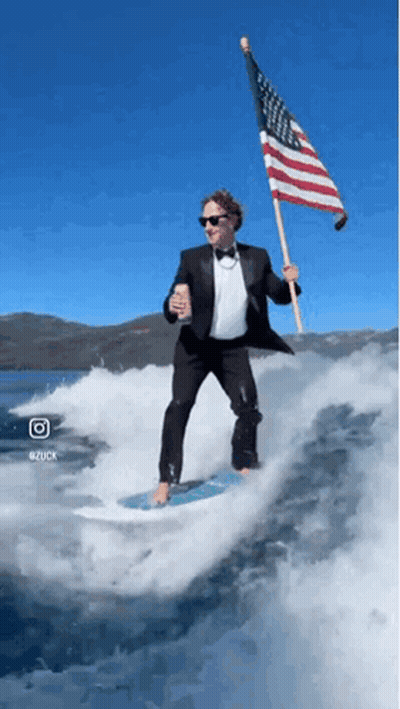 Man In Tuxedo Holding American Flag Riding Wave GIF
