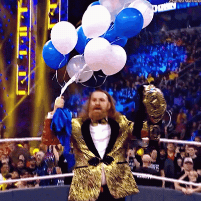 Man In Tuxedo Holding Balloons In Front Of Crowd GIF