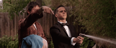 Man In Tuxedo Holding Hose While Another Man Holds Towel GIF