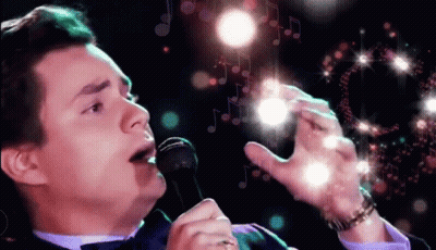 Man In Tuxedo Holding Mic And Wine GIF
