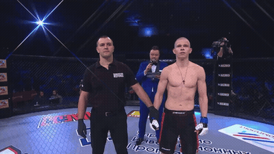 Man In Tuxedo Holding Microphone In Front Of Man In Black Panasonic Shirt GIF