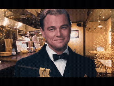 Man In Tuxedo Holding Noodles And Smiling GIF