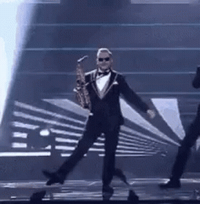 Man in Tuxedo Holding Saxophone on Stage