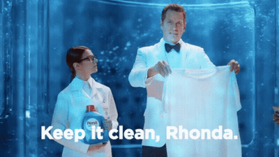 Man In Tuxedo Holding Shirt Next To Woman In Lab Coat GIF