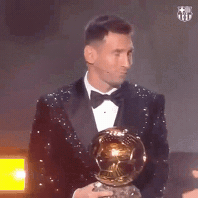 Man In Tuxedo Holding Soccer Ball And Trophy GIF