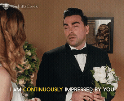 Man In Tuxedo Holding White Flowers Says I Am Continuously Impressed By You GIF