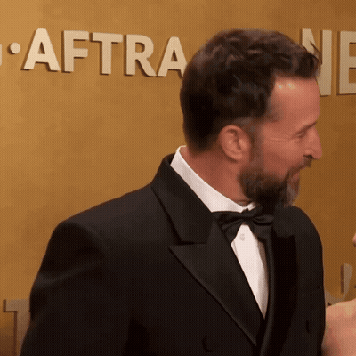 Man In Tuxedo In Front Of Aftra Wall GIF