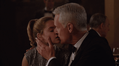 Man In Tuxedo Kissing Woman In Dress GIF