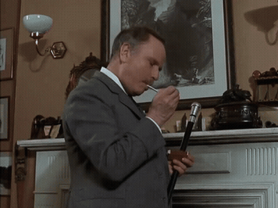 Man In Tuxedo Looks At Camera GIF