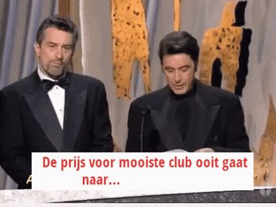 Man In Tuxedo Next To Man With Sign De Prijs Voor Mooiste Club Ooit Gaat GIF