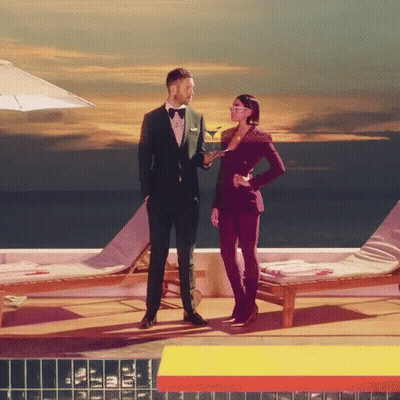 Man In Tuxedo Next To Woman Holding Martini GIF