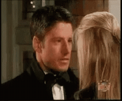 Man In Tuxedo Next To Woman In Black Jacket GIF