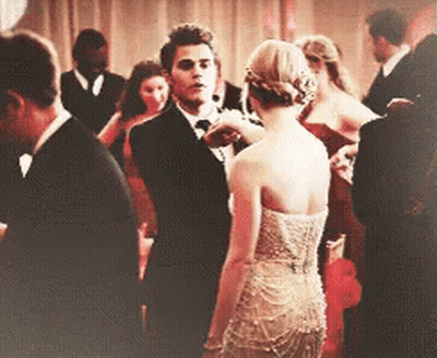 Man In Tuxedo Next To Woman In Dress GIF