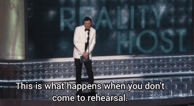 Man In Tuxedo On Stage With Reality Host Sign GIF