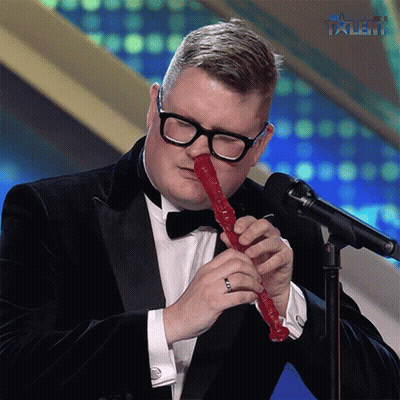 Man In Tuxedo Playing Red Recorder With Talent GIF