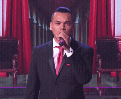 Man In Tuxedo Singing Into Microphone GIF