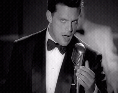 Man In Tuxedo Singing Into Microphone GIF