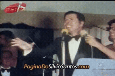 Man In Tuxedo Singing Into Microphone With Paginadossilviosantos.com GIF