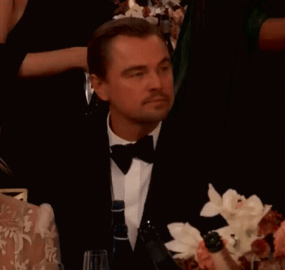 Man In Tuxedo Sitting At Table Pointing GIF