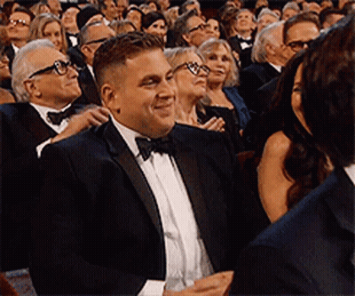 Man In Tuxedo Sitting In Crowd GIF