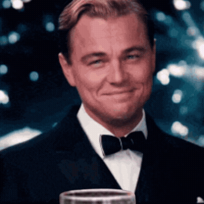 Man In Tuxedo Smiling Holding Wine GIF
