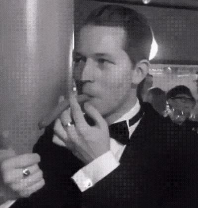 Man In Tuxedo Smoking Cigar With Ring GIF