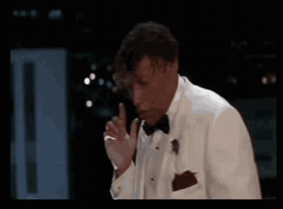 Man In Tuxedo Smoking Cigarette In Dark Room GIF