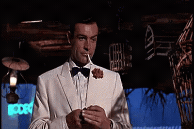 Man In Tuxedo Smoking In Dark Room GIF