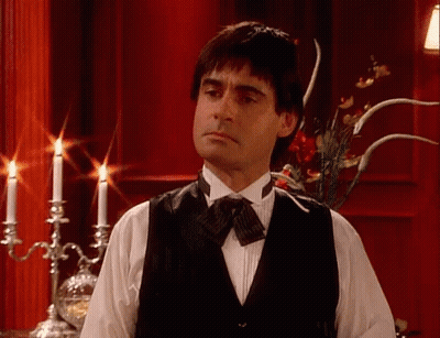 Man In Tuxedo Standing In Front Of Candle Holder GIF