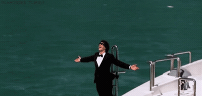 Man In Tuxedo Standing In Front Of White Yacht GIF