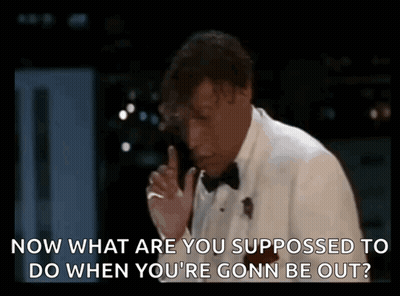 Man In Tuxedo Talking On Phone With Finger To Lips GIF