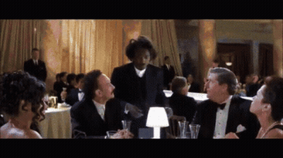 Man In Tuxedo Talking To Group At Tables GIF